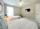 Bedroom with two twin beds, a TV, and a ceiling fan at 2955 Beach Palm Ave, Kissimmee, FL 34747