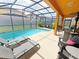 Relax by the pool with plenty of seating and a screened enclosure at 2955 Beach Palm Ave, Kissimmee, FL 34747
