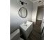 Clean bathroom with a white vanity and round mirror at 1541 N Hudson St, Orlando, FL 32808