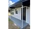 Front entrance of the home with a black door and gray concrete walkway at 1541 N Hudson St, Orlando, FL 32808