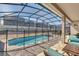 Screened-in pool with patio furniture and fenced backyard at 1770 Sawyer Palm Pl, Kissimmee, FL 34747