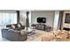 Relaxing living room with gray leather couches and a large TV, open to kitchen at 1754 Caribbean View Ter, Kissimmee, FL 34747