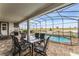 Covered patio with pool, table and chairs, overlooking a scenic landscape at 1754 Caribbean View Ter, Kissimmee, FL 34747