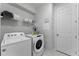 Bright laundry room with Whirlpool washer and dryer, shelving and hanging rod at 1754 Caribbean View Ter, Kissimmee, FL 34747