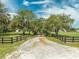 Property entrance with black metal gate and wooden fence, leading to a long driveway at 4450 Kaiser Ave, St Cloud, FL 34772