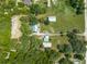 Aerial view of a house with pool and large lot, showing surrounding land and outbuildings at 4450 Kaiser Ave, St Cloud, FL 34772