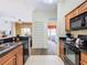 Open kitchen with granite counters, black appliances, and view of living space at 8125 Resort Village Dr # 51104, Orlando, FL 32821