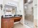 Double vanity bathroom with granite countertop, large mirror, and walk-in shower at 8125 Resort Village Dr # 51104, Orlando, FL 32821