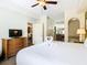 King-size bed, dresser, and en-suite bathroom with a soaking tub at 8125 Resort Village Dr # 51104, Orlando, FL 32821