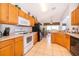 Kitchen with wooden cabinets, white appliances, and tile floor at 8612 La Isla Dr, Kissimmee, FL 34747