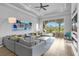 Spacious living room with hardwood floors, large windows, and access to outdoor patio at 494 Muirfield Loop, Reunion, FL 34747