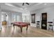 Game room with pool table, dartboard, and bar stools at 494 Muirfield Loop, Reunion, FL 34747