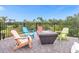Relaxing patio with fire pit and colorful chairs at 494 Muirfield Loop, Reunion, FL 34747