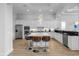 Modern white kitchen with marble island, stainless steel appliances, and hardwood floors at 494 Muirfield Loop, Reunion, FL 34747