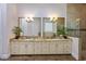 Double vanity bathroom with granite countertops and large mirrors at 1125 Grand Traverse Pkwy, Reunion, FL 34747