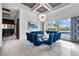 Elegant dining room with a large glass table and blue velvet chairs, offering pool views at 1125 Grand Traverse Pkwy, Reunion, FL 34747