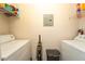 Bright laundry room with washer, dryer, and shelving at 3593 Conroy Rd # 437, Orlando, FL 32839