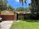 House exterior featuring a brown garage door, stone accents, and a well-maintained lawn at 1250 Pecan St, Kissimmee, FL 34744