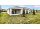 Home's backyard with covered patio, grassy area, and landscaping at 176 Flag Lilly Ln, Umatilla, FL 32784