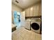Bright laundry room with washer, dryer, and ample cabinet space at 12351 Northover Loop, Orlando, FL 32824
