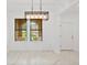 Dining room with large windows, tile floor, and modern chandelier at 840 Crooked Branch Dr, Clermont, FL 34711