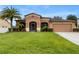 One-story house with a two-car garage and palm trees at 840 Crooked Branch Dr, Clermont, FL 34711