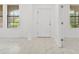 Bright entryway with white door and marble-look tile floors at 840 Crooked Branch Dr, Clermont, FL 34711