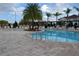 Community pool with plenty of lounge chairs and palm trees at 3208 Cupid Pl, Kissimmee, FL 34747