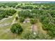 Aerial view of a house on a large lot with surrounding trees and open fields at 950 S Narcoossee Rd, St Cloud, FL 34771