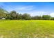 Expansive grassy field with oak trees and a bright blue sky at 950 S Narcoossee Rd, St Cloud, FL 34771