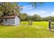 Small gray shed with a red metal roof in a grassy area at 950 S Narcoossee Rd, St Cloud, FL 34771