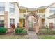 Two-story building with brick arch entryway, lush landscaping, and inviting yellow exterior at 5012 Laguna Bay Cir # 74, Kissimmee, FL 34746