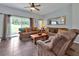 Relaxing living room with brown sofas, tiled floors, and a view of the backyard at 2758 Sun Key Pl, Kissimmee, FL 34747