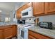 White kitchen stove with granite countertop and wood cabinets at 2758 Sun Key Pl, Kissimmee, FL 34747