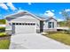 One-story home with gray siding, stone accents, and a two-car garage at 4063 Bannock Ave, Tavares, FL 32778