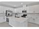 Modern kitchen with white cabinets, stainless steel appliances, and an island at 4063 Bannock Ave, Tavares, FL 32778
