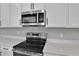 Modern kitchen with stainless steel appliances and white cabinets at 4063 Bannock Ave, Tavares, FL 32778