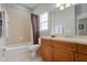 Clean bathroom with tub, shower, and wood vanity at 7714 Excitement Dr, Reunion, FL 34747