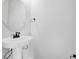 Small bathroom with pedestal sink and round mirror at 180 Flag Lilly Ln, Umatilla, FL 32784