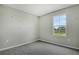Bright bedroom with grey walls and carpet, featuring one window at 180 Flag Lilly Ln, Umatilla, FL 32784