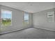 Spacious bedroom with neutral walls and carpet, featuring three windows with natural light at 180 Flag Lilly Ln, Umatilla, FL 32784