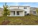 Two-story house with covered patio and grassy backyard at 180 Flag Lilly Ln, Umatilla, FL 32784