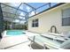 Inviting pool area with screened enclosure, lounge chairs, and a lush green lawn at 648 Copeland Dr, Haines City, FL 33844
