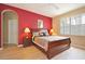 Main bedroom features a sleigh bed and a red accent wall at 648 Copeland Dr, Haines City, FL 33844