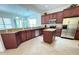Spacious kitchen with dark wood cabinets, granite countertops and island at 709 Carmel Ln, Kissimmee, FL 34759
