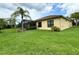 Home exterior showcasing a large backyard with tropical landscaping at 709 Carmel Ln, Kissimmee, FL 34759