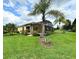 Landscaped backyard with tropical plants and screened patio at 709 Carmel Ln, Kissimmee, FL 34759
