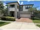 Modern two-story house with stone facade and two-car garage at 2414 Fenetre Ln, Kissimmee, FL 34741