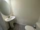 Powder room with pedestal sink, toilet, and oval mirror at 4422 Small Creek Rd # 72, Kissimmee, FL 34744