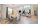 Elegant dining room with a large table, grey chairs and a modern chandelier at 2744 Bookmark Dr, Kissimmee, FL 34746